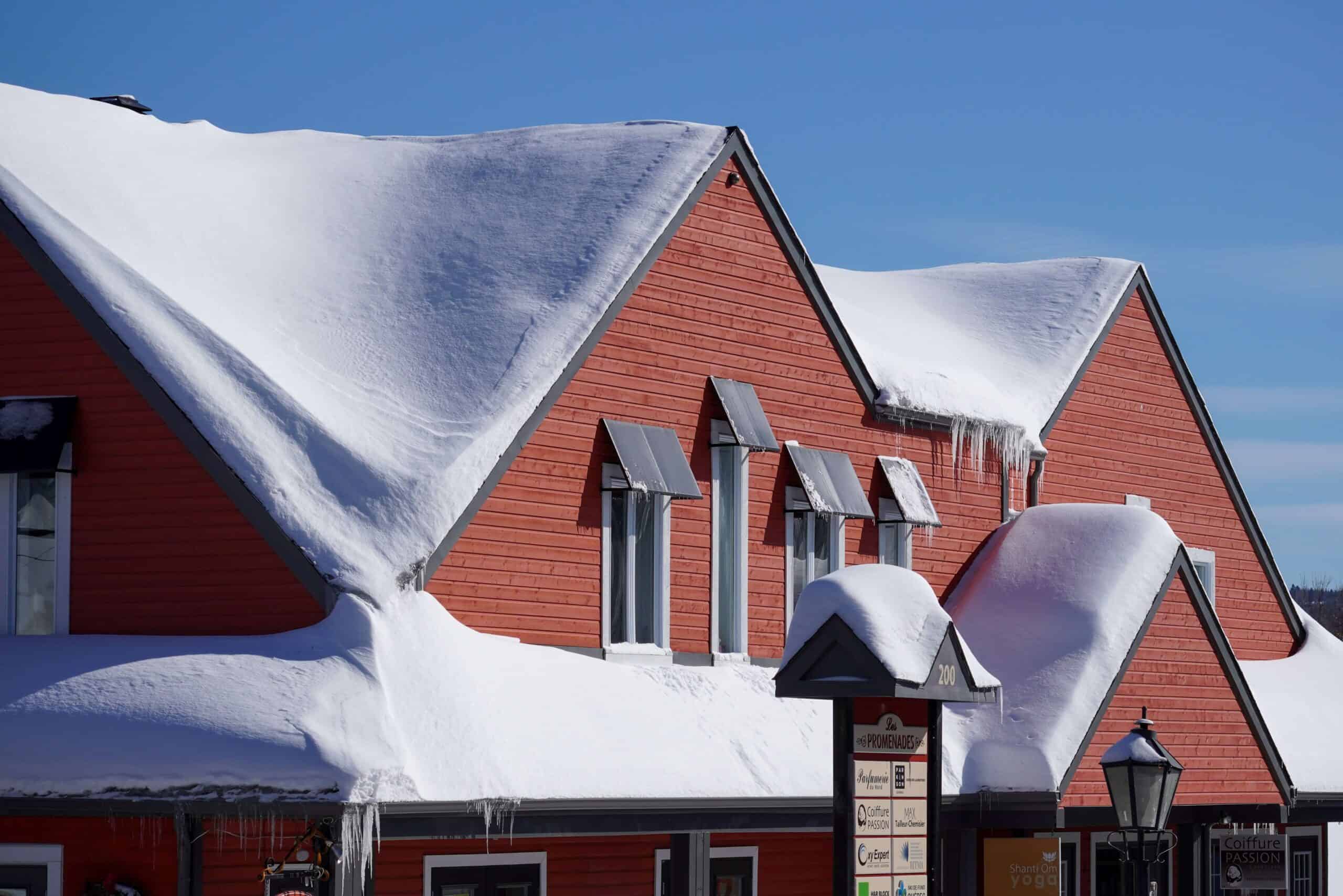 snow covered house with red siding installation by local roofing company