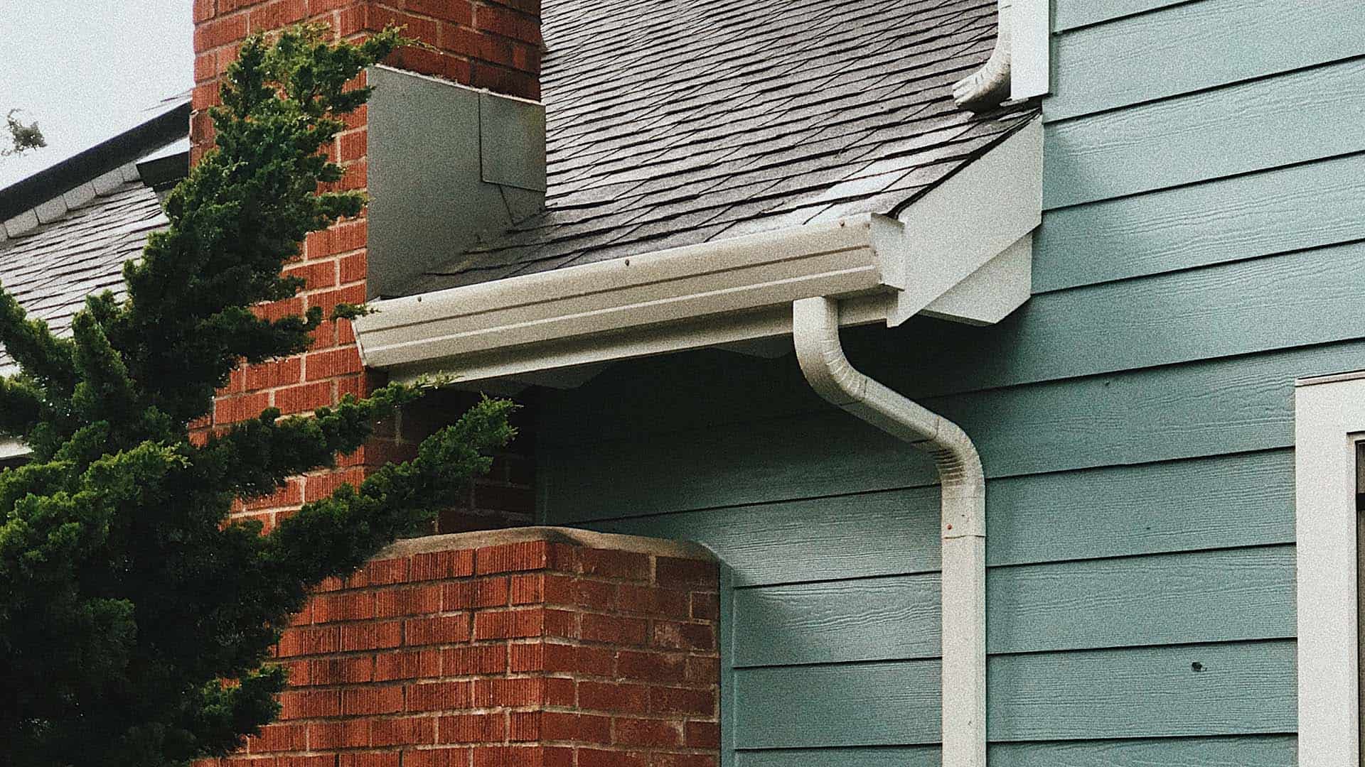 picture of side of a house showing the gutter sidings and chimney