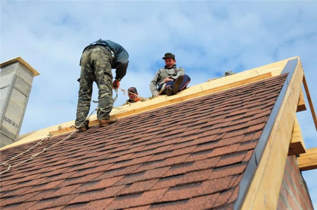 A group of Omaha roofing professionals repair an asphalt shingle roof.