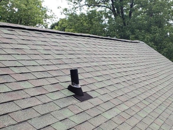 A chimney cap on the asphalt shingle roof of an Omaha home.