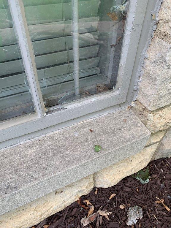 Window broken on Omaha home, caused by recent omaha hail storm. One panel of window is shattered with a visible hole