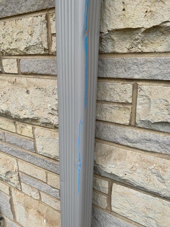 Hail damage spots on Omaha home downspout
