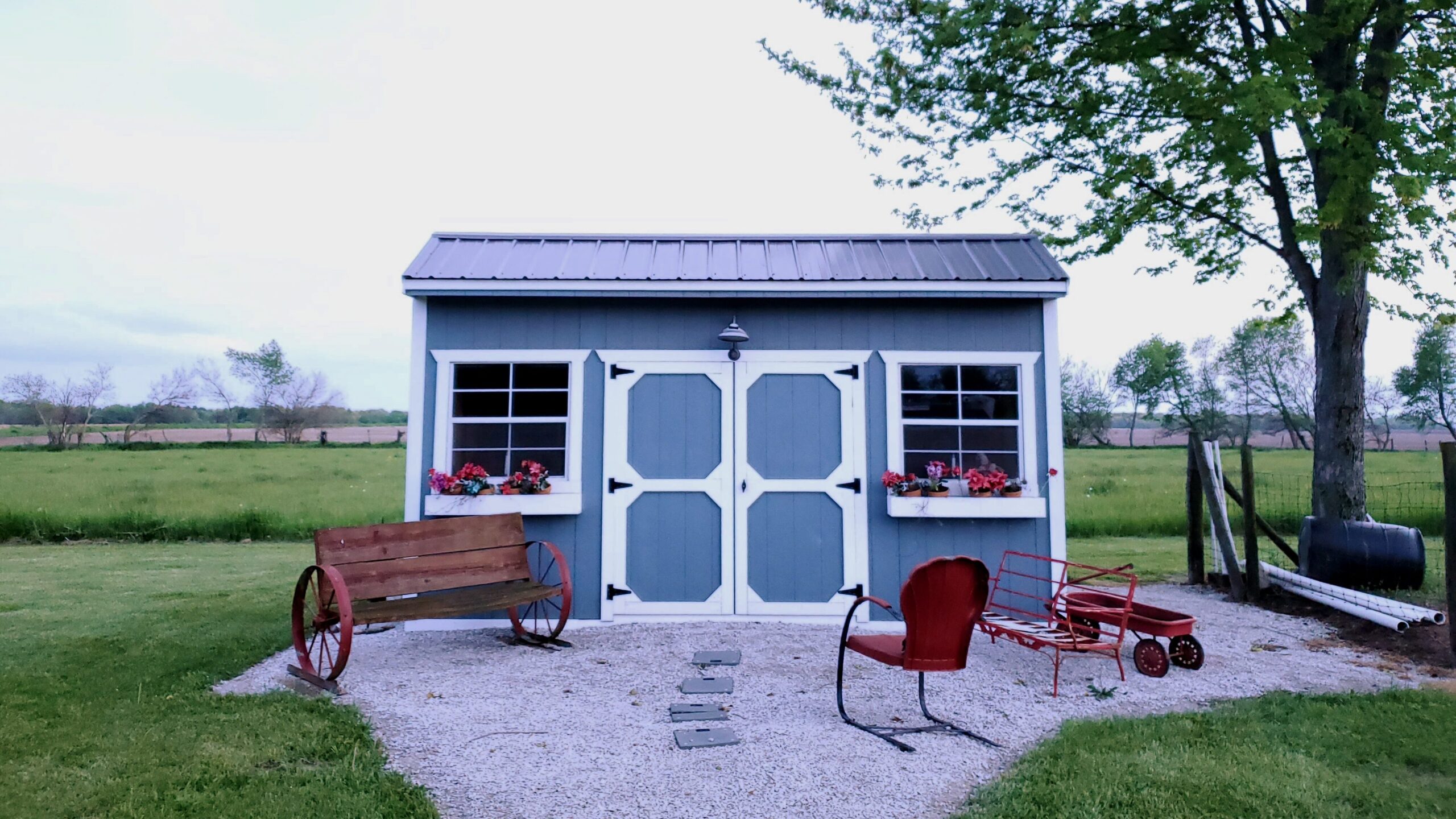 outdoor image of a blue shed with white trim and red chair in front in Lincoln, NE