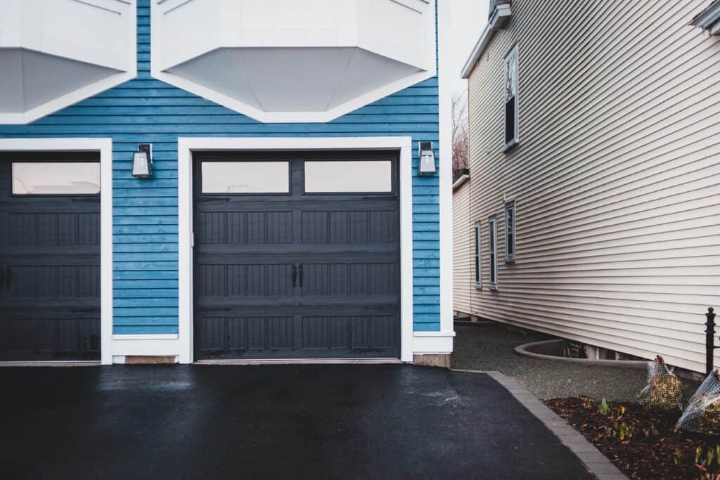 Navy Garage door with blue siding installation Des Moines roofing company