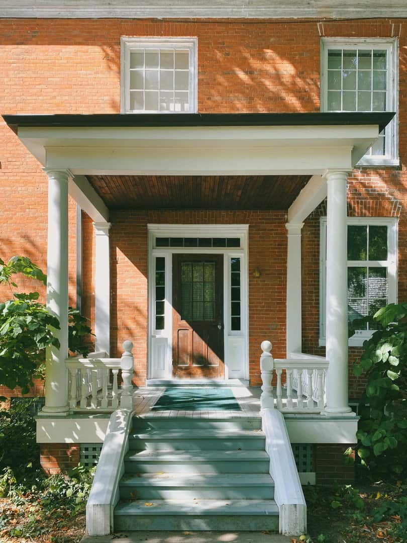 Front of brick house with new covered front porch from Des Moines Roofing Company