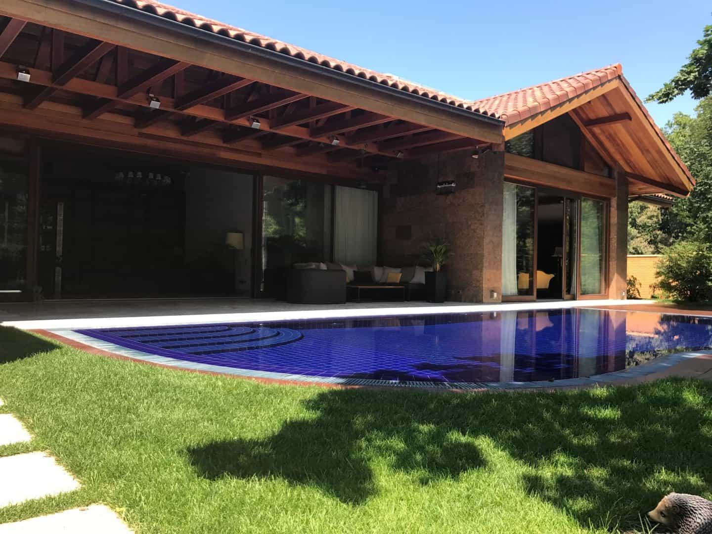 A Des Moines home with roof tiles and a pool in the yard.