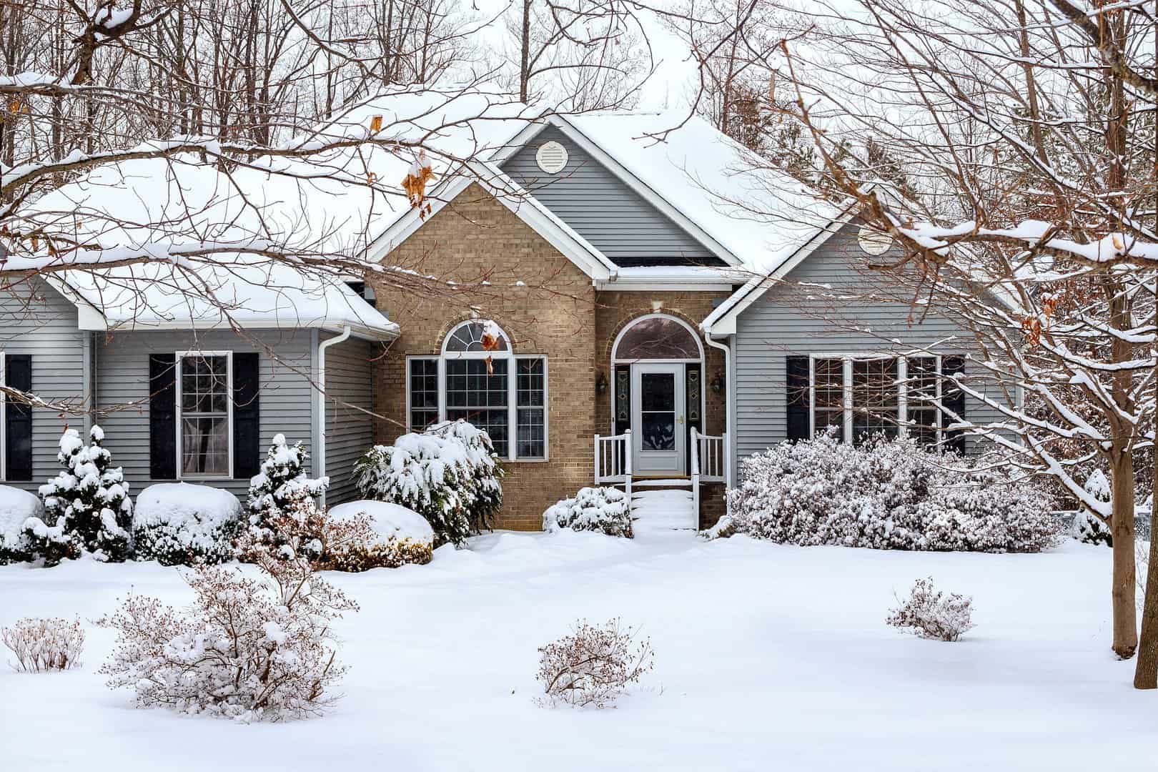 An Omaha home with grey vinyl siding after a recent snowstorm.